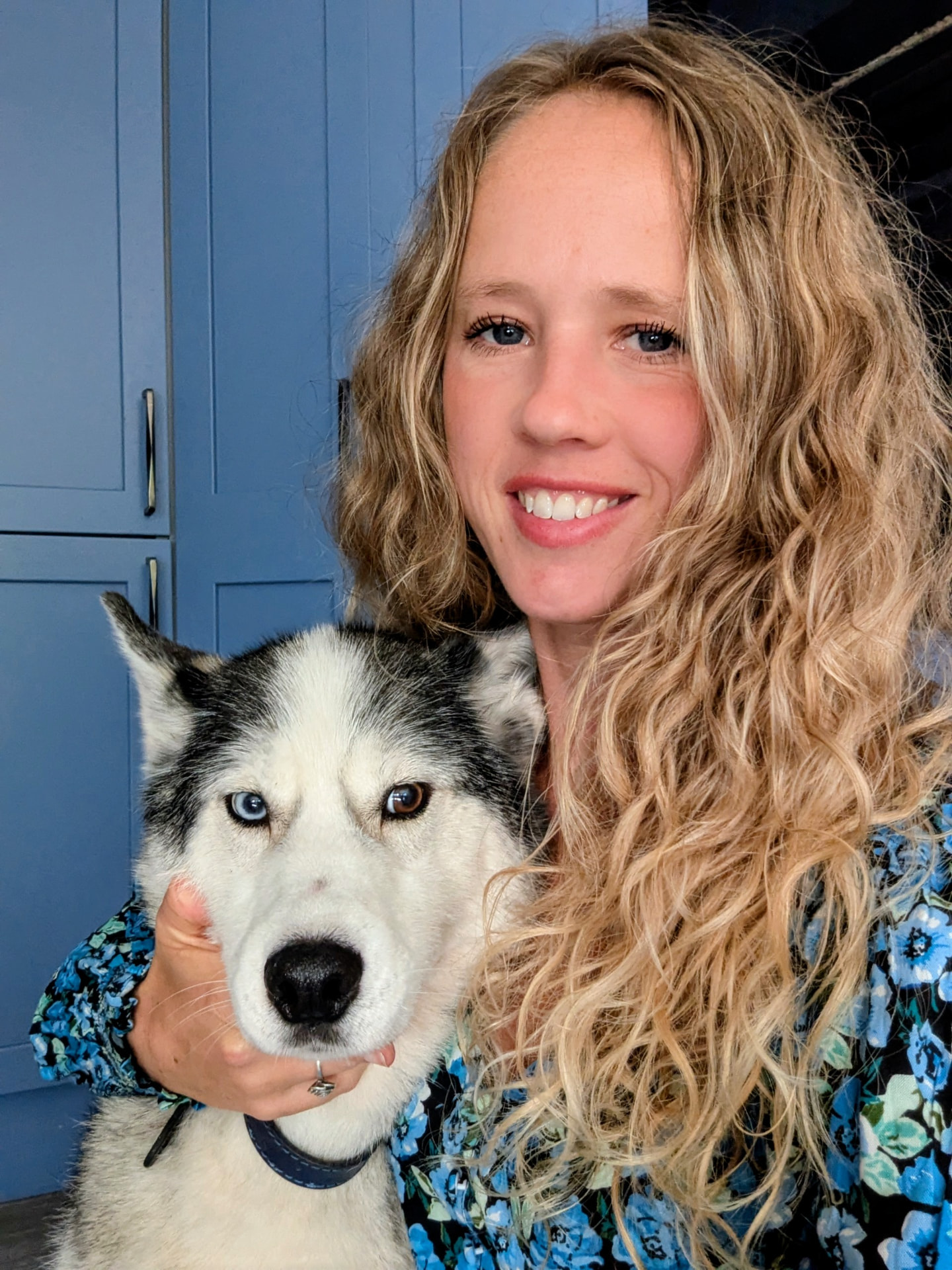 Kiri smiling with her husky close beside her